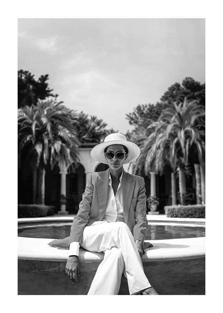 Black and white photo of woman in suit and sun hat by pool-12