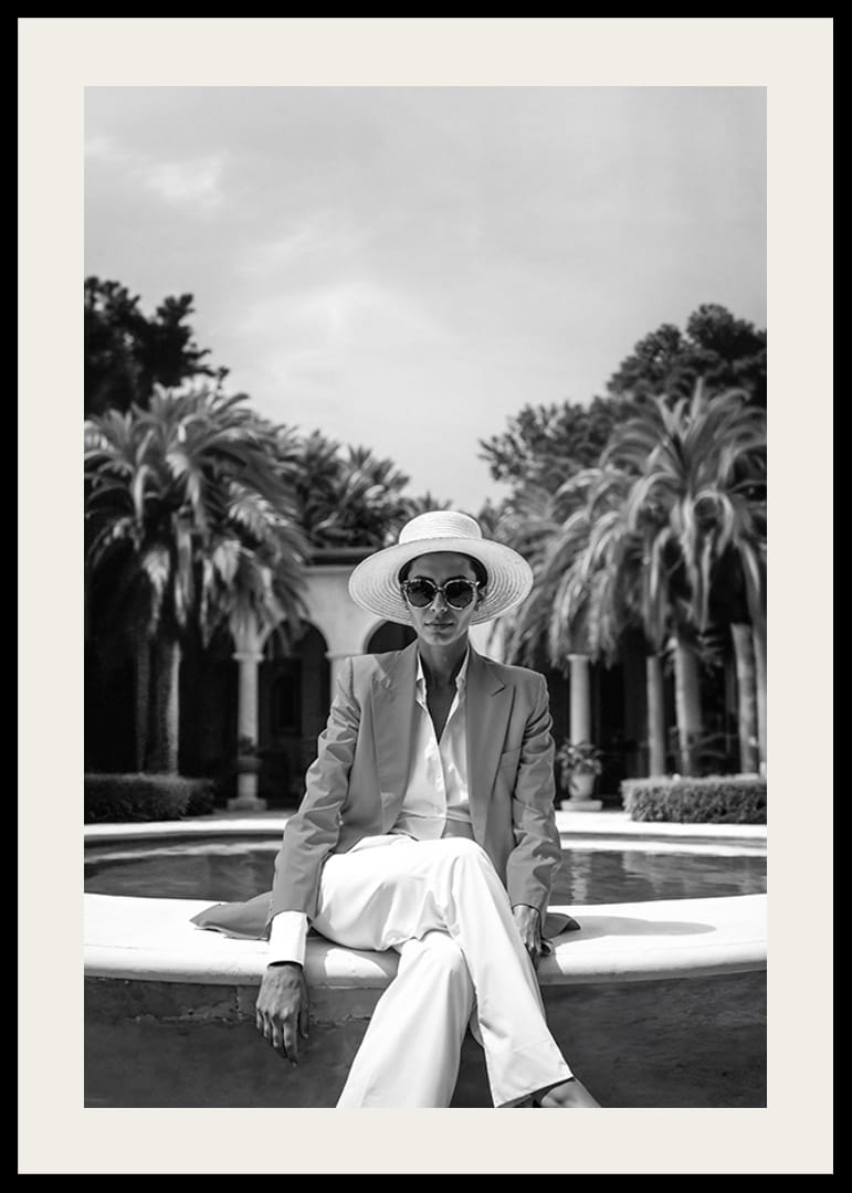 Black and white photo of woman in suit and sun hat by pool-12
