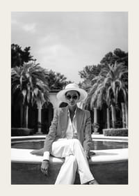 Black and white photo of woman in suit and sun hat by pool-3