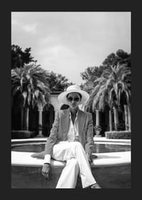 Black and white photo of woman in suit and sun hat by pool-5