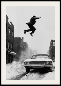 Schwarz-weiße Stadtszene mit Mann, der über ein schneebedecktes Auto springt-2