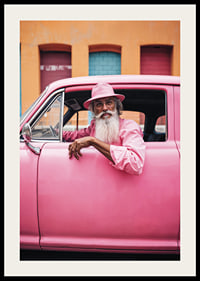 Elderly man with long beard in pink car in front of colorful facade-2