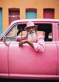 Elderly man with long beard in pink car in front of colorful facade-7