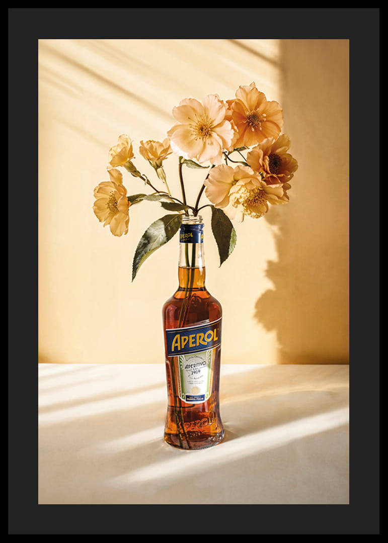 Fotografia della bottiglia di Aperol con fiori gialli brillanti in una luce soleggiata-12
