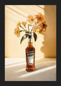 Fotografia della bottiglia di Aperol con fiori gialli brillanti in una luce soleggiata-5