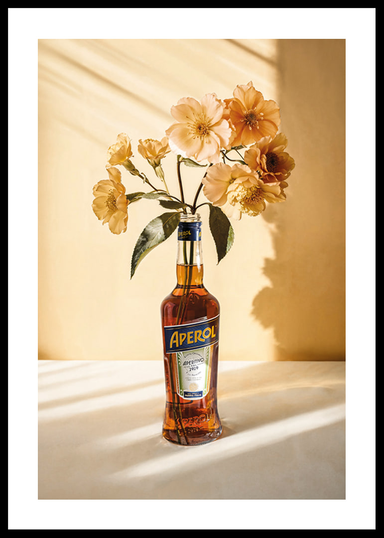 Fotografi av Aperolflaska med ljusgula blommor i soligt ljus-12