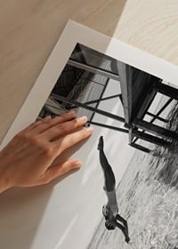 Svartvit poster med ett fotografi på en kvinna som dyker från en träbrygga-9