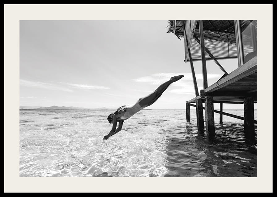 Svartvit poster med ett fotografi på en kvinna som dyker från en träbrygga-12
