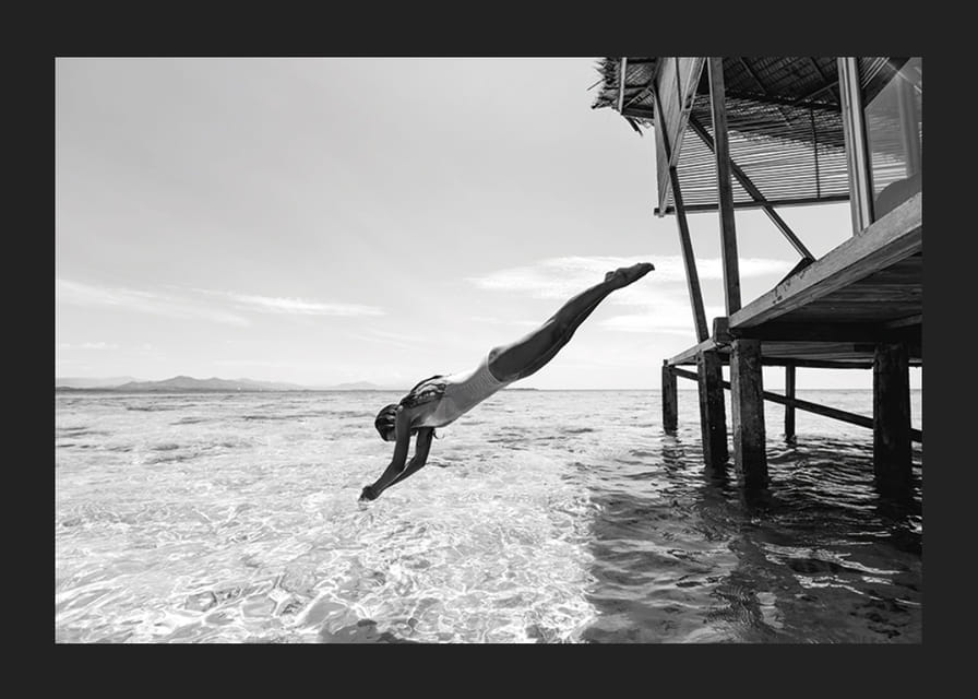 Svartvit poster med ett fotografi på en kvinna som dyker från en träbrygga-12