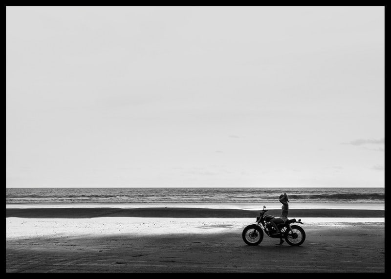 Black and white poster with a photograph of a lone motorcycle on a deserted beach-12