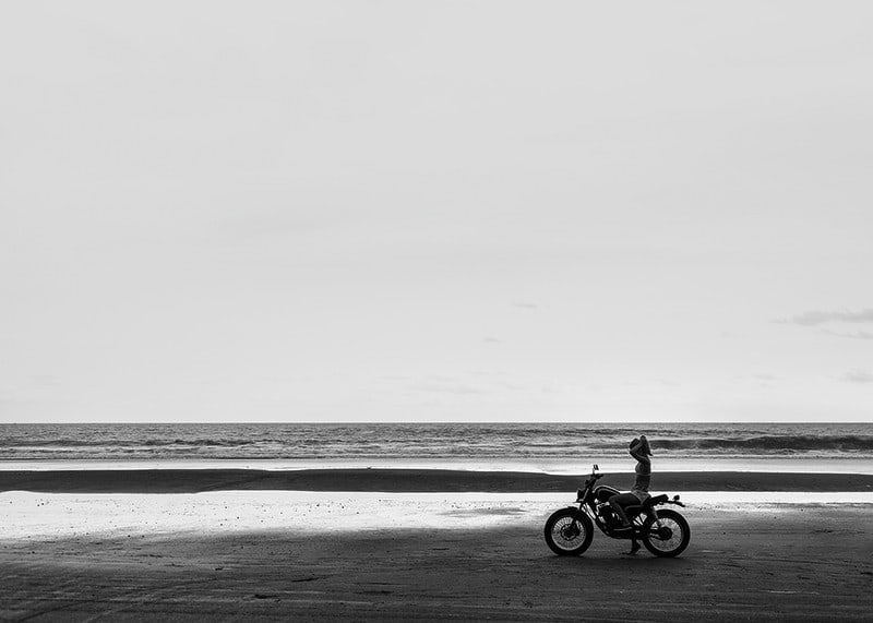 Black and white poster with a photograph of a lone motorcycle on a deserted beach-12