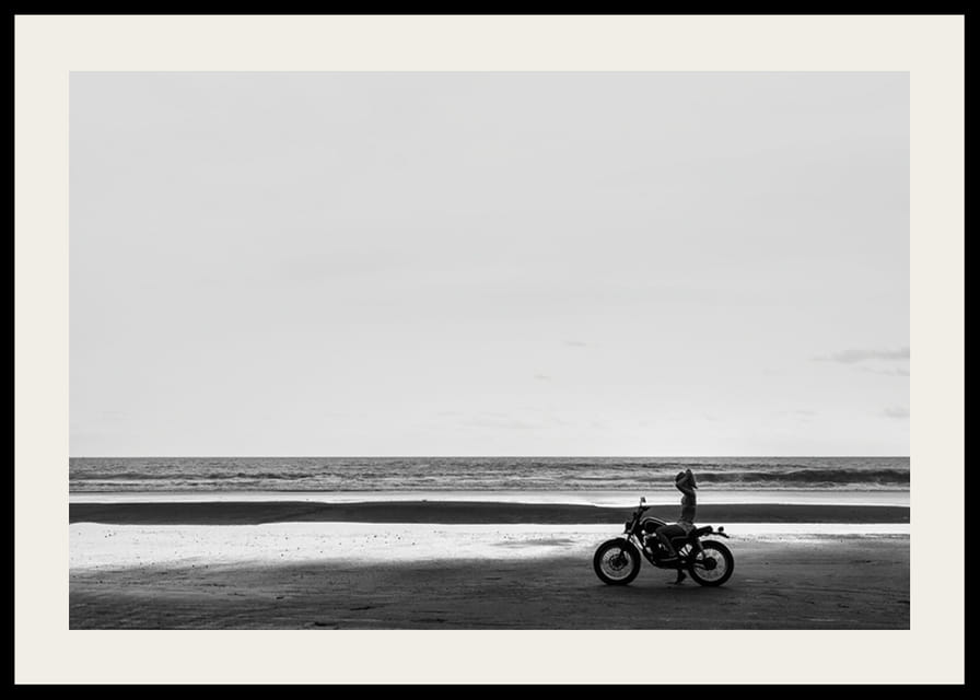 Svartvit poster med ett fotografi på en ensam motorcykel på en ödslig strand-12
