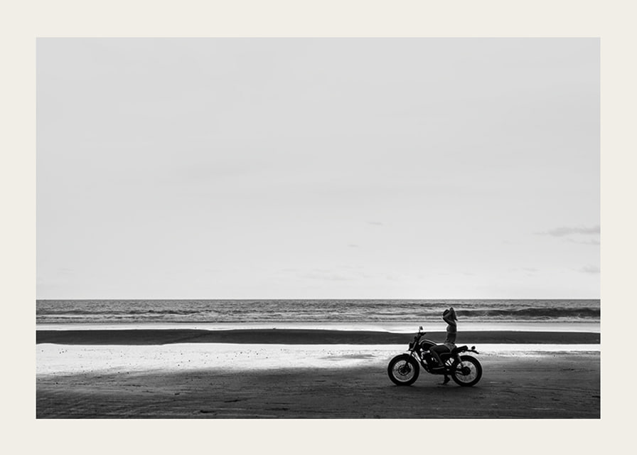 Black and white poster with a photograph of a lone motorcycle on a deserted beach-12