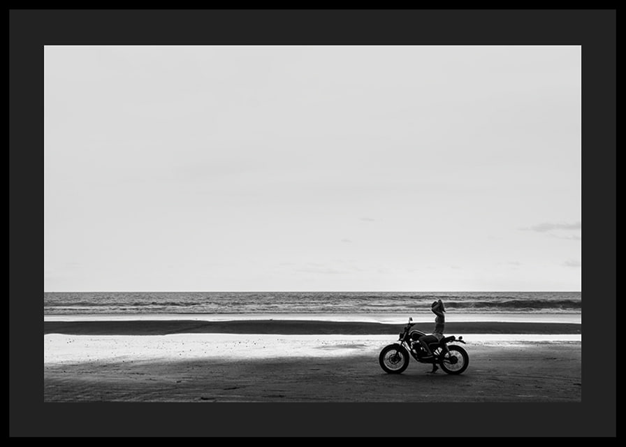 Black and white poster with a photograph of a lone motorcycle on a deserted beach-12