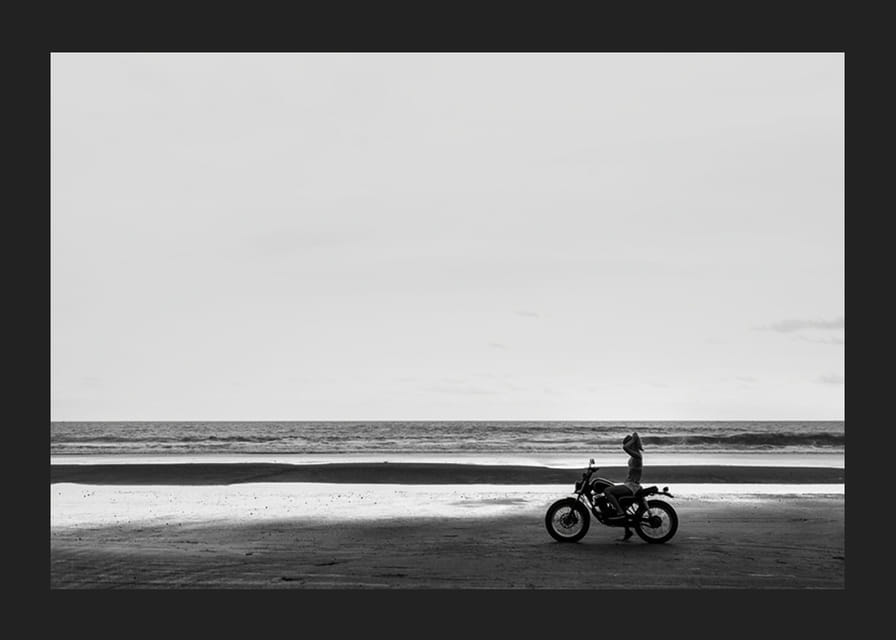 Svartvit poster med ett fotografi på en ensam motorcykel på en ödslig strand-12