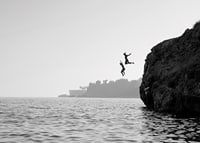 Black and white poster with a photograph of two people jumping from a cliff into the sea-7