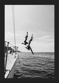 Svartvit poster med ett fotografi på två personer som hoppar från en segelbåt ner i havet-5