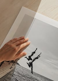 Black and white poster with a photograph of two people jumping from a sailboat into the sea-9