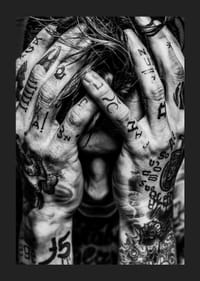 Melnbalts plakāts ar vīrieša fotogrāfiju, kura seja ir paslēpta tetovētajās rokās-1