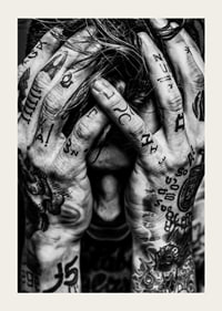 Black and white poster with a photograph of a man with his face hidden in his tattooed hands-5