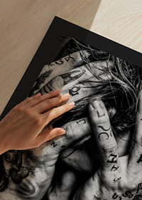 Black and white poster with a photograph of a man with his face hidden in his tattooed hands-9