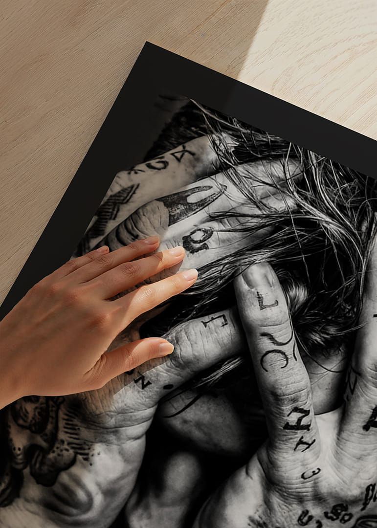Melnbalts plakāts ar vīrieša fotogrāfiju, kura seja ir paslēpta tetovētajās rokās-12