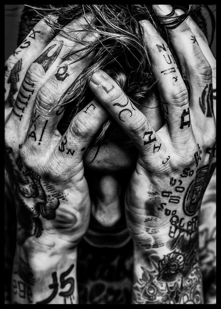 Black and white poster with a photograph of a man with his face hidden in his tattooed hands-12
