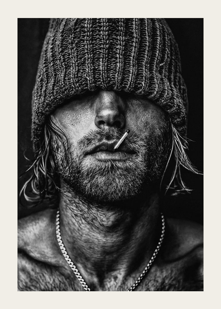 Black and white poster with a photograph of a man with a cap pulled down over his eyes-12