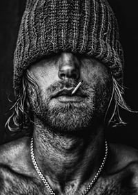 Black and white poster with a photograph of a man with a cap pulled down over his eyes-7
