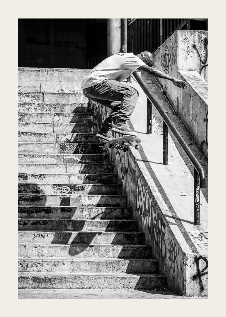 Svartvit poster med ett fotografi på en skateboardåkare som hoppar nerför en trappa-12