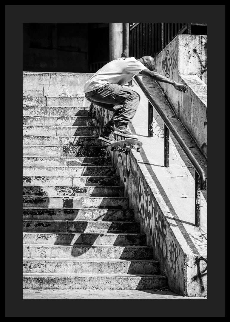 Svartvit poster med ett fotografi på en skateboardåkare som hoppar nerför en trappa-12