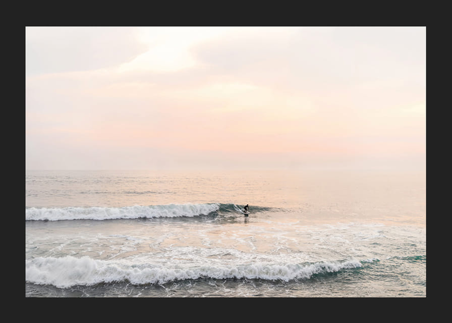 Poster med ett fotografi på en ensam surfare på havet bland vågorna-12