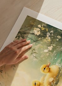 En poster med tre fluffiga andungar som simmar i stilla vatten omgivet av blommor-9