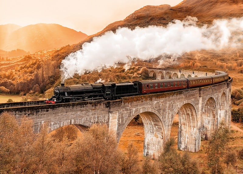 Poster met een afbeelding van een trein op een brug in een herfstlandschap-12