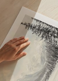 A poster of snow-capped mountains and a peaceful valley, framed by stately firs-9