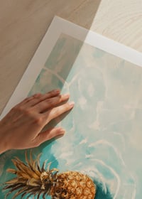 A poster of a golden pineapple floating on crystal clear water-9