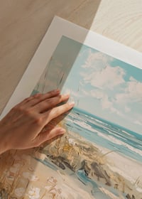 A poster of a sunny beach with sand dunes and a sparkling ocean in the background-9