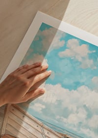 Ein Poster eines klassischen Holzboots, das an einem sonnigen Strand mit dem Meer im Hintergrund ruht-9