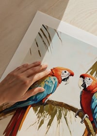 A poster of two parrots resting on a palm branch in a tropical setting-9