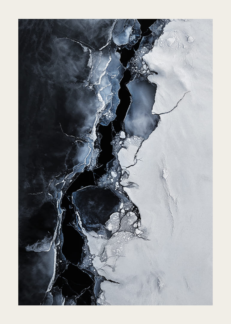 Pęknięty lód spotyka się z ciemną wodą, tworząc dramatyczny kontrast, który oddaje surowe piękno zimy-12