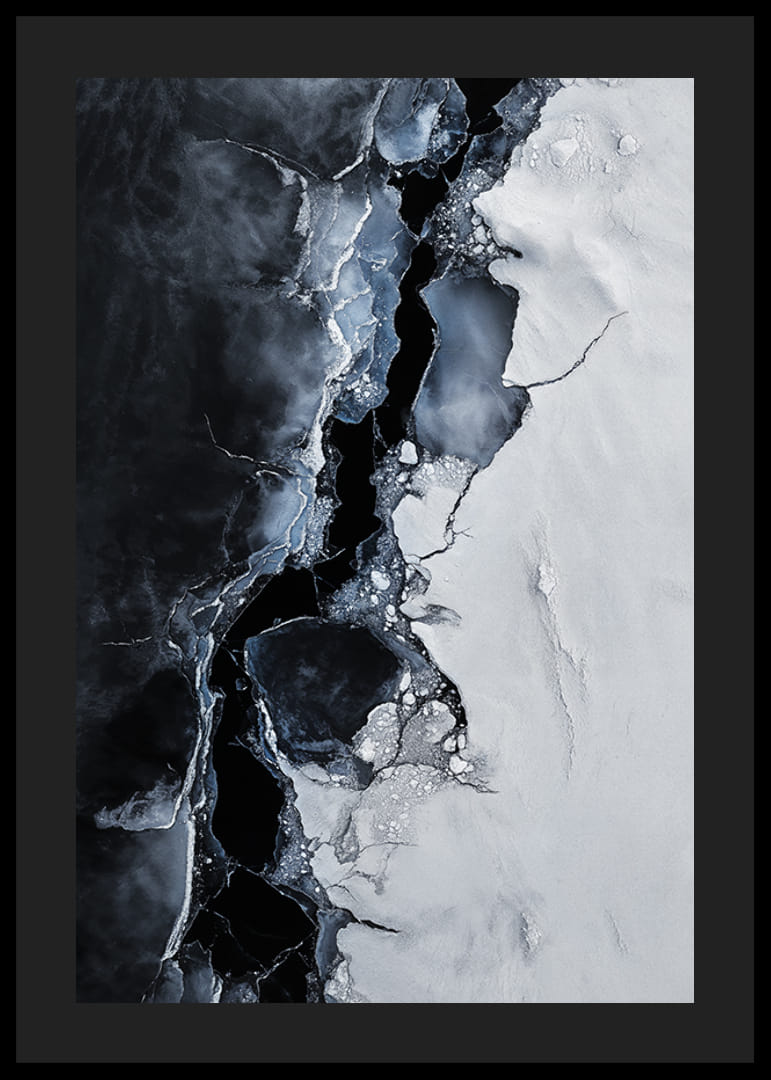 Pęknięty lód spotyka się z ciemną wodą, tworząc dramatyczny kontrast, który oddaje surowe piękno zimy-12