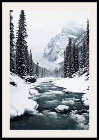 Une rivière calme serpente à travers une forêt enneigée, entourée de hautes montagnes et de la beauté tranquille de l'hiver-2