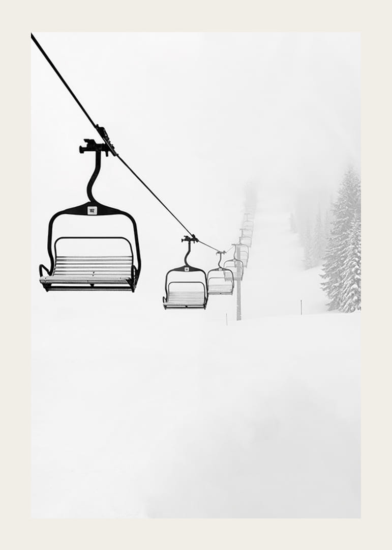 An empty ski lift stretches through a snow-covered landscape, capturing the quiet and peaceful beauty of winter-12