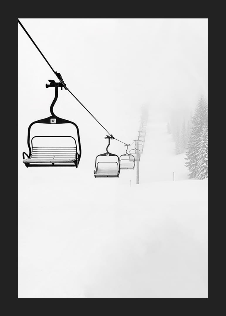 An empty ski lift stretches through a snow-covered landscape, capturing the quiet and peaceful beauty of winter-12