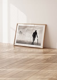 En ensam figur står med ett paraply och blickar ut över en dimhöljd stad, fångad i ett ögonblick av stillhet och reflektion.-8
