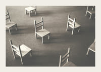 En minimalistisk bild av tomma stolar spridda över ett golv, som symboliserar stillhet och utrymme för eftertanke-3