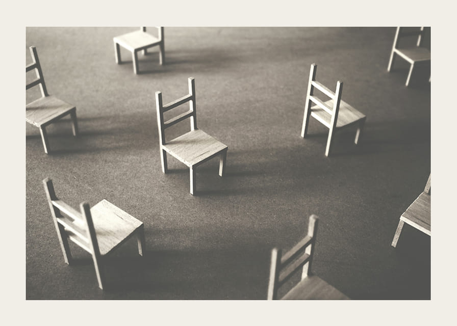 En minimalistisk bild av tomma stolar spridda över ett golv, som symboliserar stillhet och utrymme för eftertanke-12