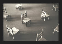 En minimalistisk bild av tomma stolar spridda över ett golv, som symboliserar stillhet och utrymme för eftertanke-5