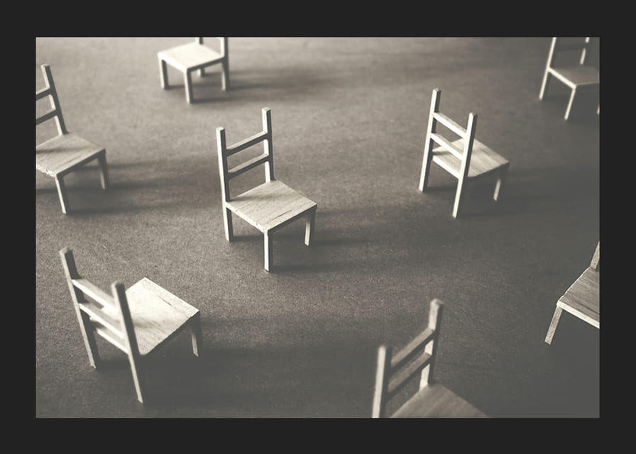 En minimalistisk bild av tomma stolar spridda över ett golv, som symboliserar stillhet och utrymme för eftertanke-12