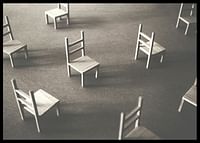 O imagine minimalistă a scaunelor goale împrăștiate pe podea, simbolizând liniștea și spațiul de reflecție-2